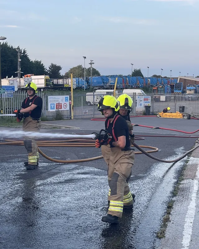 Volunteer firefighters running hoses